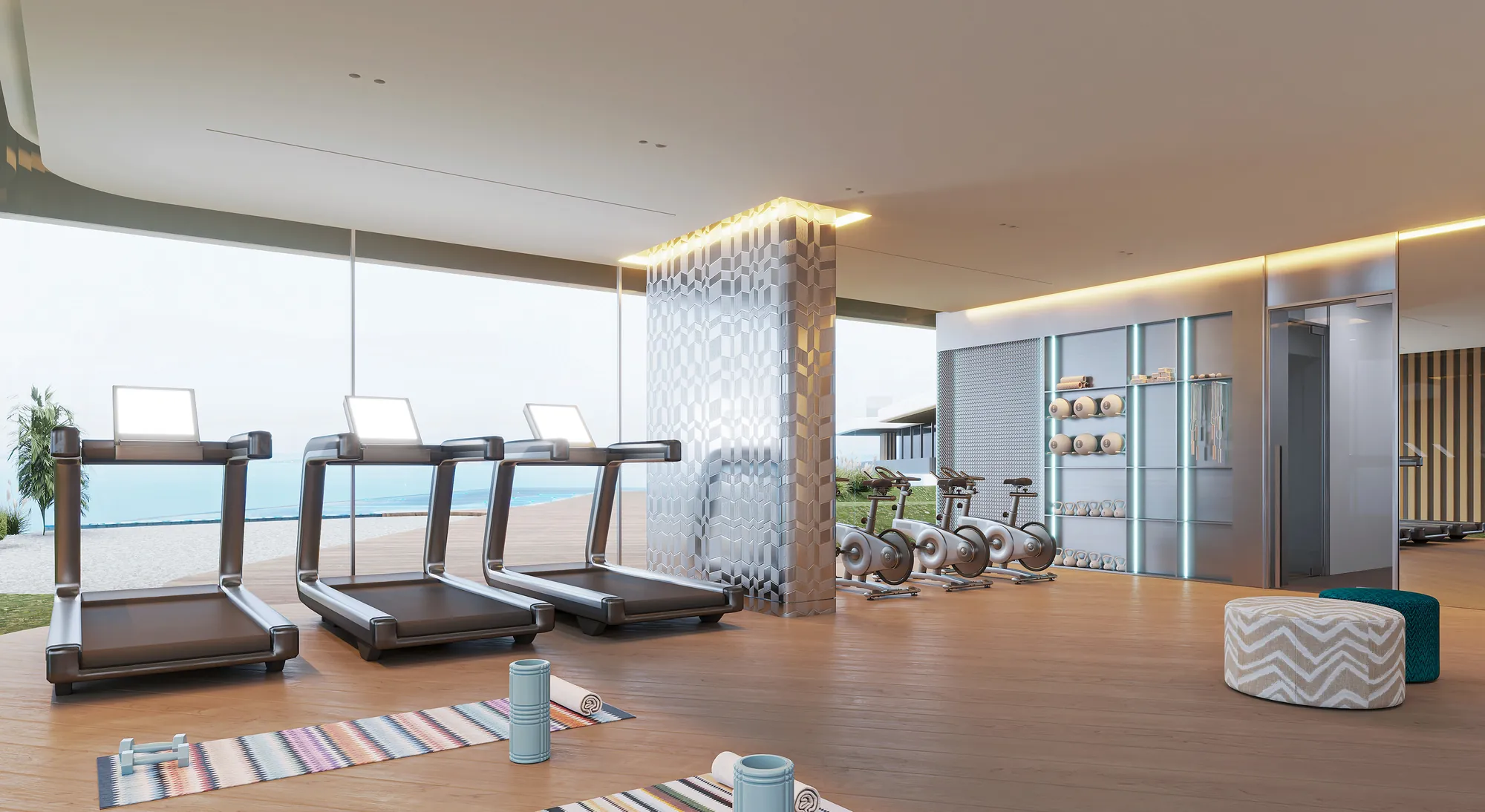 Gym at The Bay Interiors by Missoni on Dubai Islands, with treadmills and exercise bikes facing the water